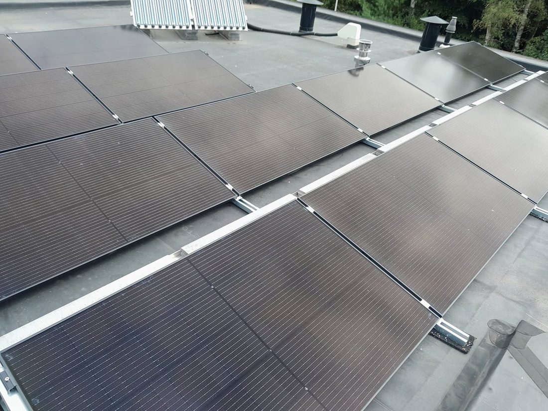 Zwarte zonnepanelen op een plat dak
